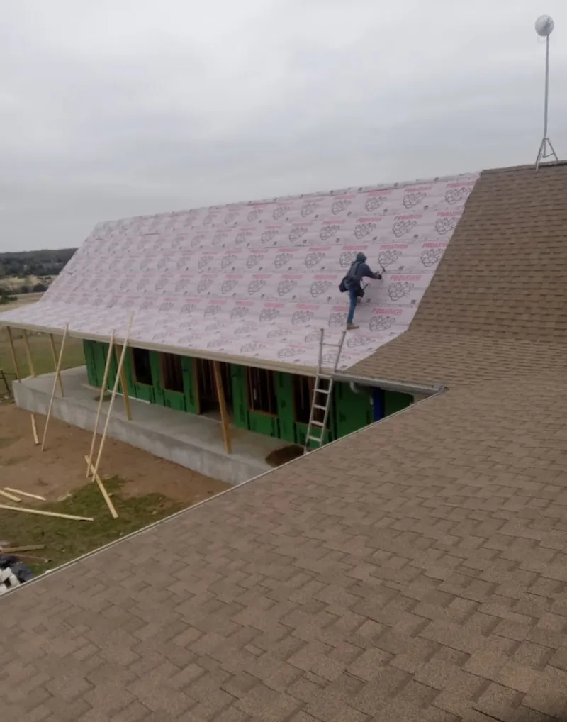Worker preparing underlayment for a metal roof installation in Hazel Crest